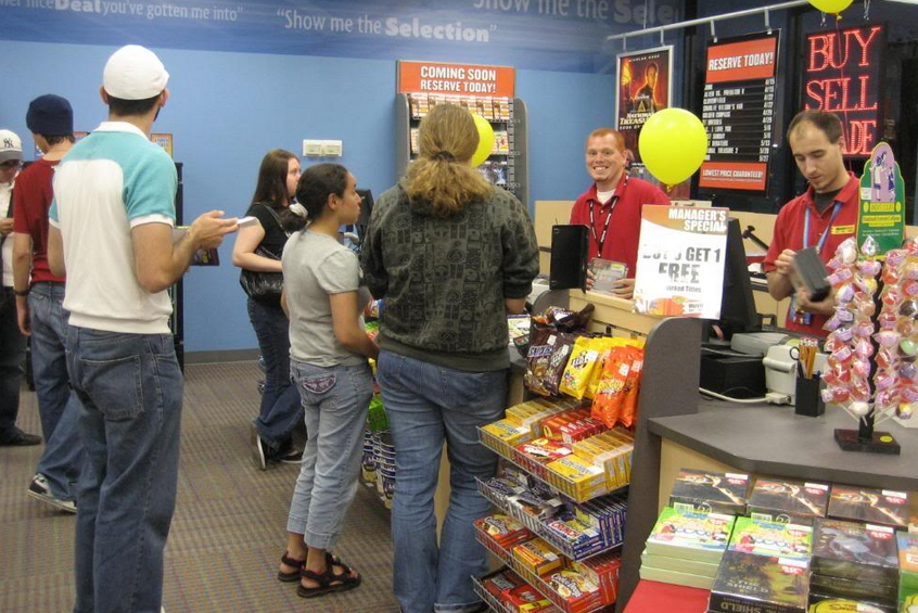 A photo of a retail employee interacting with a customer queue