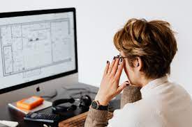  a small business owner sitting at a desk, looking at a statement with payment options and due dates listed. 